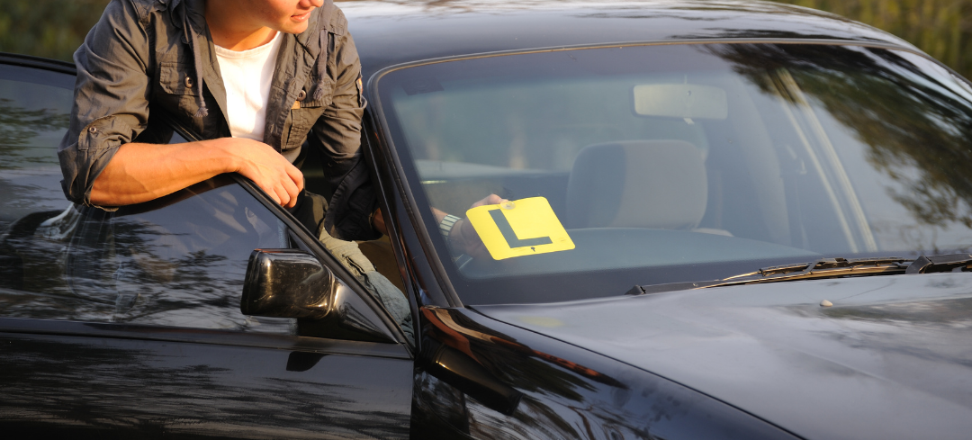 Image of a young person placing Learners plates on their vehicle.